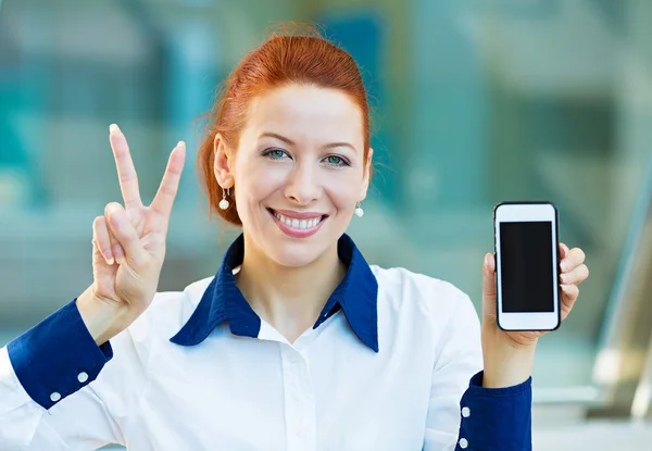 Happy woman showing her smart phone giving victory sign