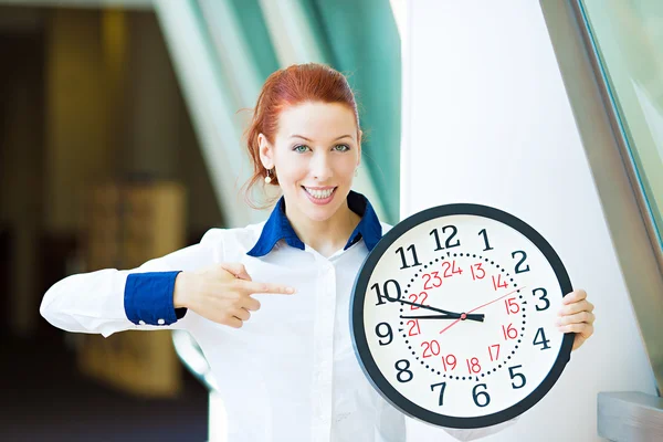 Business woman pointing on wall clock