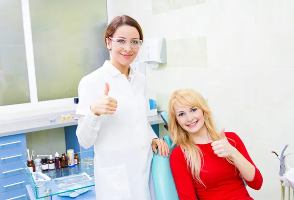 Female patient in dentist office giving thumbs up