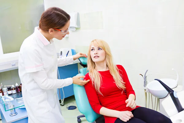 Woman patient in dentist office getting consultation from doctor