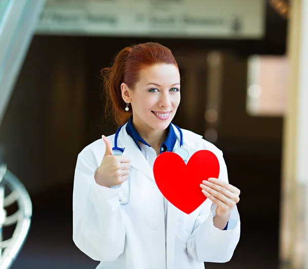 Doctor holding heart giving thumbs up