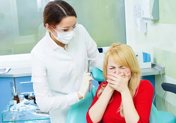 Young patient in dentist office, afraid of anesthetic injection,