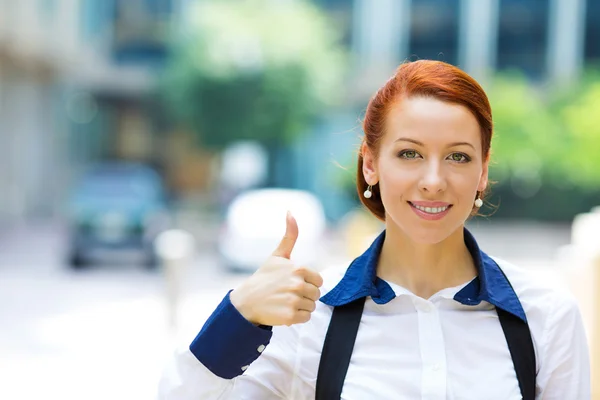 Business woman giving thumbs up