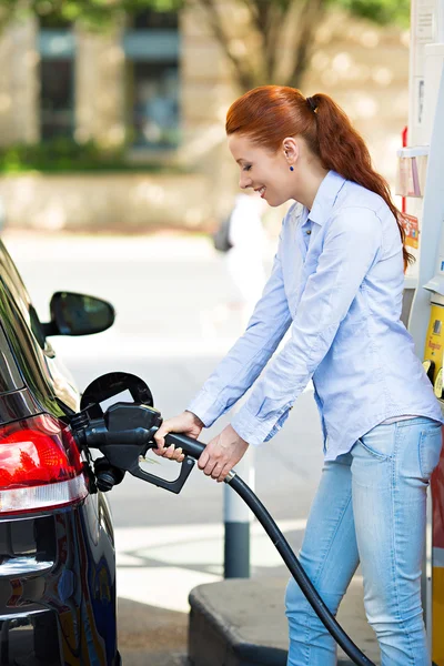 Woman at gas station, filling up her car
