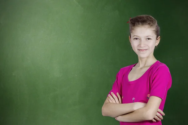Confident happy, young student standing by chalkboard