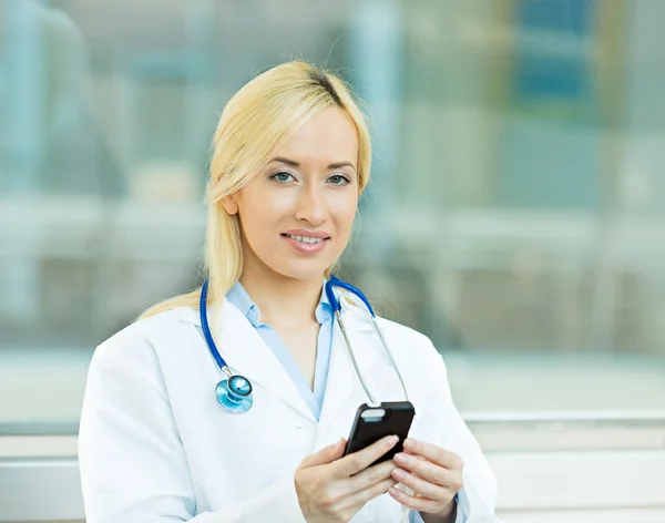 Female health care professional, doctor holding smart phone