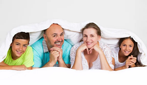 Happy, smiling family under the blanket