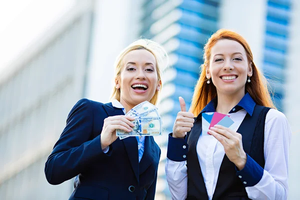 Happy business women holding credit cards and cash reward
