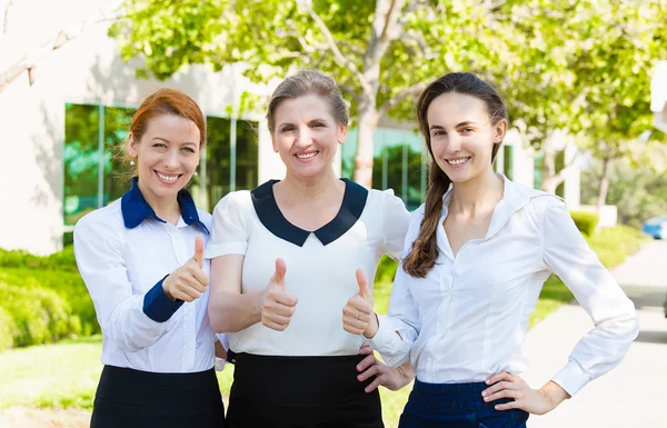 Successful business women giving thumbs up