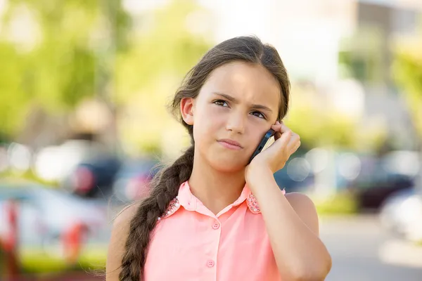 Unhappy, sad girl talking on smart phone