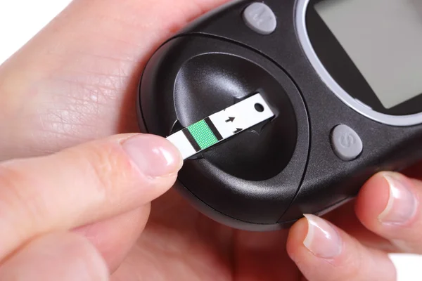 Closeup of glucose meter and finger