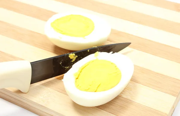 Two halves of egg with ceramic knife