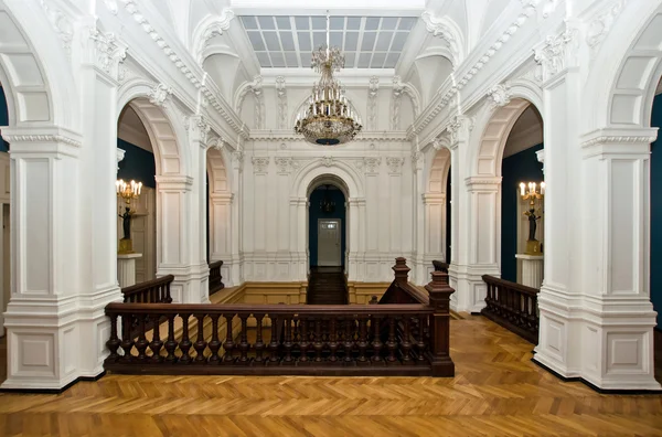 Grand hall in old majestic palace with oak staircase