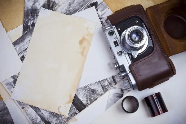 Retro camera with film strip and old photographs