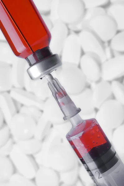 Medical vial and syringe on white pills