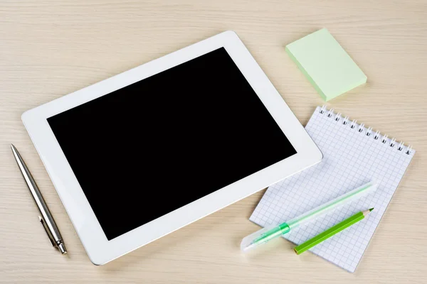 Tablet pc with notes, pen and pensils on table surface