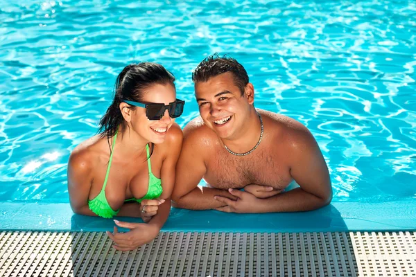 Cute happy bikini woman with nice breast in swimming pool with h