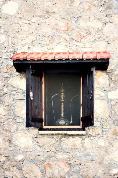 Open wooden window shutter on stone wall. Traditional greece windows with decoration