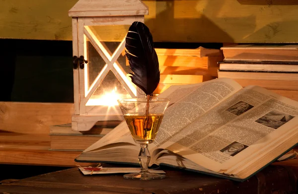 Opened book, glass, feather, lamp