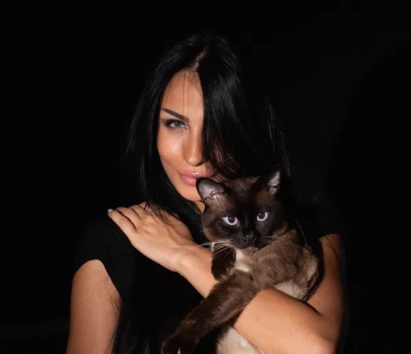 Beautiful and sexy woman with a Siamese Cat isolated on black background