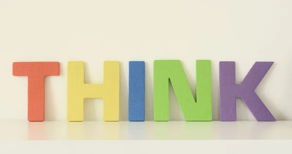 Word THINK, in colorful upper case letters of foam toys