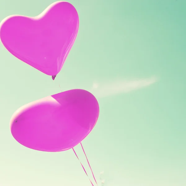 Purple heart balloons on mint sky