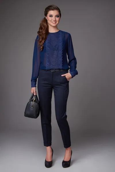 Beautiful sexy young business woman with evening make-up dressed in tight pants and silk blouse with lace long sleeves and high-heeled shoes and a small black handbag, business clothes meetings walks