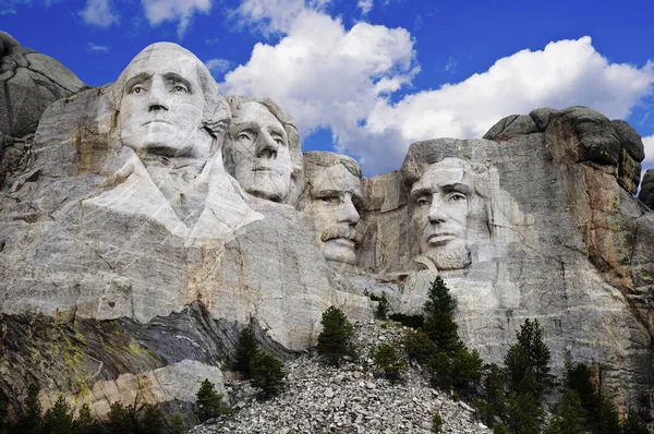 Mt. Rushmore National Memorial Park in South Dakota with bright blue sky in background.