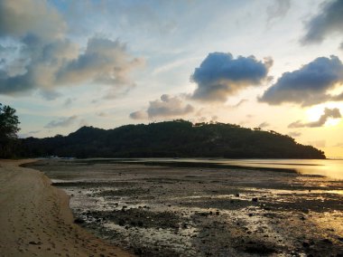 Akşamüstü okyanus kıyısındaki tropik bir adanın sahilinde..