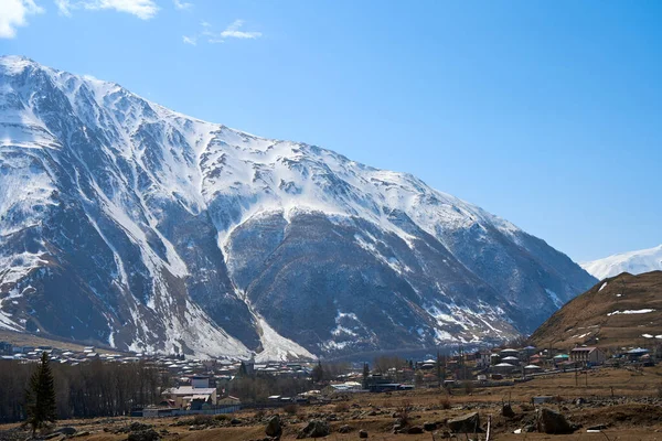 Início Primavera Aldeia Fica Nas Montanhas Bonés Neve Topo Das — Fotografia de Stock