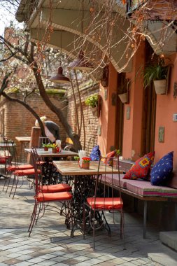 Tiflis 'in eski ve sıcak bir bölgesinde, caddedeki yazlık teras ve restoran masası..