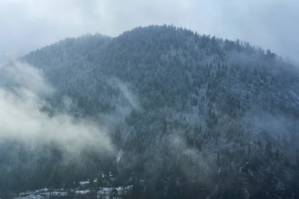 冬季山地景观 小城镇在山间 城市上空笼罩着一片云彩 — 图库照片