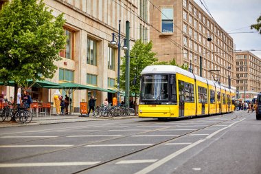 Modern sarı şehir tramvayı bir toplu taşıma durağında. Berlin, Almanya - 05.17.2019