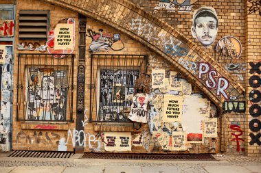 Getto bölgesi, duvarlar grafiti ile boyanmış, pencereler parmaklıkların arkasında. Üzerinde 