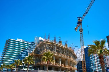 Deniz kenarındaki modern bir binanın inşaat sahasında kule vinci..