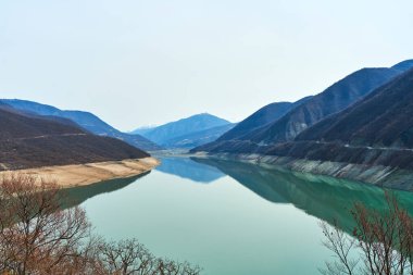 Gürcistan dağlarındaki Zhinvali rezervuarı. Dağların arka planındaki gök mavisi su.