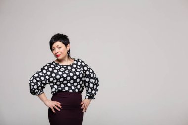 Stüdyoda beyaz arka planda poz veren bir kadın..