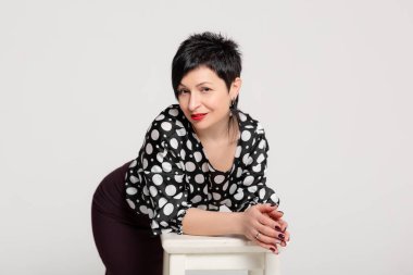 Stüdyoda beyaz arka planda poz veren bir kadın..