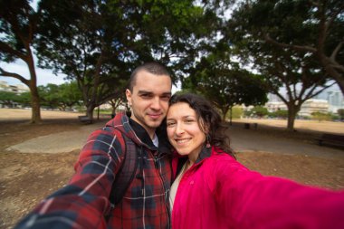 Mutlu genç çift kucaklaşarak selfie çekiyor..