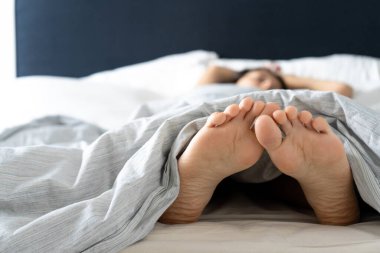 Sabahları yatakta uyuyan bir kızın ayakları. Casus fotoğrafı
