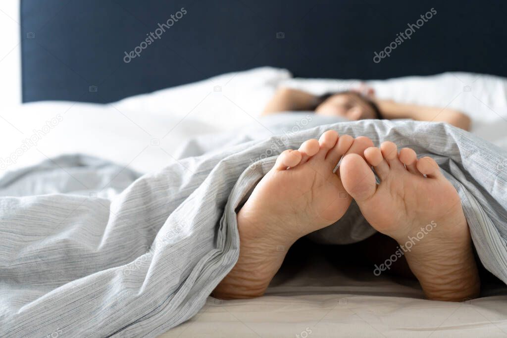 Feet of a sleeping girl in bed in the morning. Spy photo