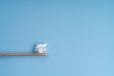 Çevre dostu trend bambu diş fırçası. Popüler diş fırçaları. Hijyen eğilimleri. Diş macunuyla üst görünüm.