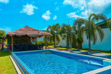 Cozy tropical resort with swimming pool in the backyard. Bright sunny day. Langkawi, Malaysia - 06.23.2020