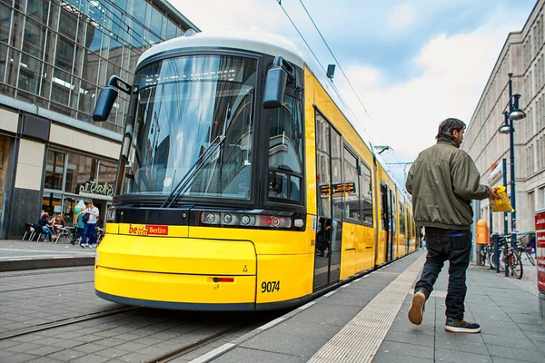 Modern sarı şehir tramvayı bir toplu taşıma durağında. Berlin, Almanya - 05.17.2019