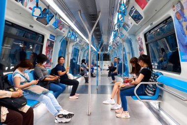 Modern bir metro vagonunun içi. Yeni güzel vagon. Metrodaki insanlar iş için gidiyorlar. Kuala Lumpur, Malezya - 03.10.2020
