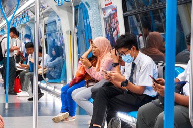 Modern bir metro vagonunun içi. Yeni güzel vagon. Metrodaki insanlar iş için gidiyorlar. Kuala Lumpur, Malezya - 03.10.2020