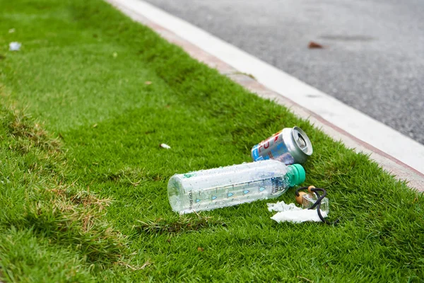 Plastic bottle and some litter on the roadside.