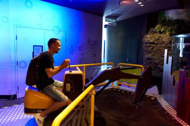 Oyuncak traktörü, ziyaretçilerin toprağı kazabileceği bir yere yerleştirin.