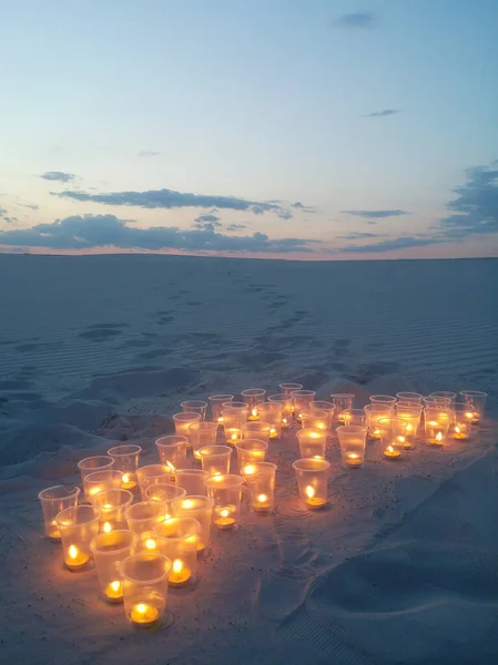 A romantic evening in a deserted place. Candles on the sand in an evening in the desert.