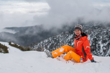 kar Hill'de oturan genç kadın kayakçı